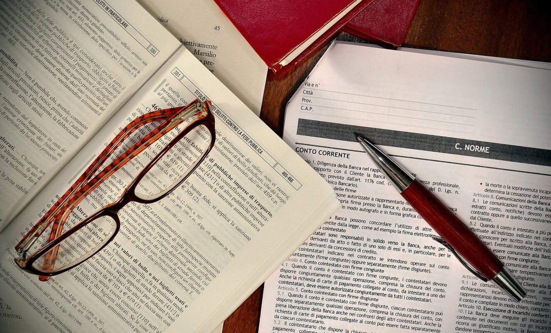 Codici di legge, occhiali e documenti sulla scrivania dello studio